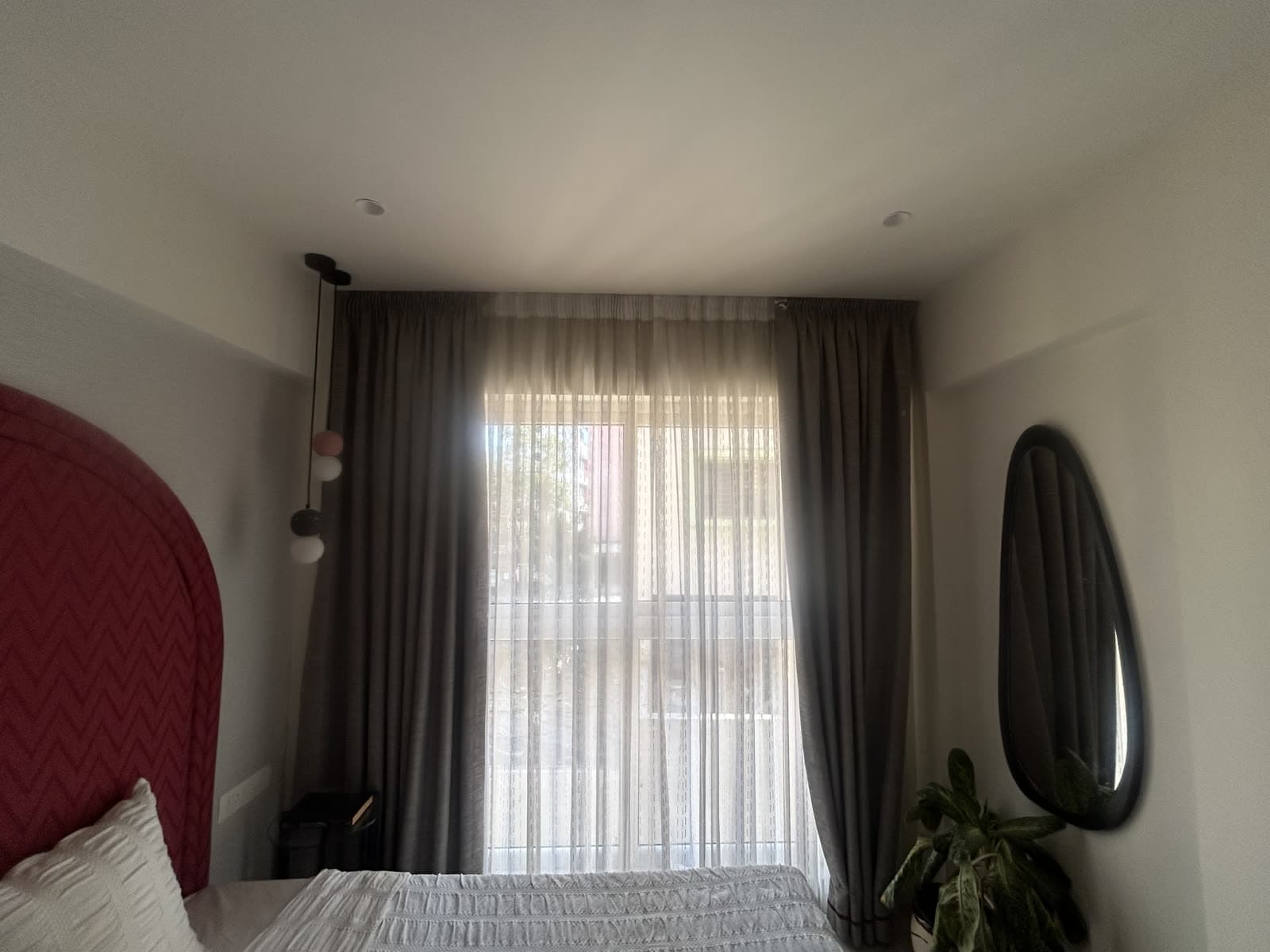 Finished bedroom with a red arched accent wall behind the headboard